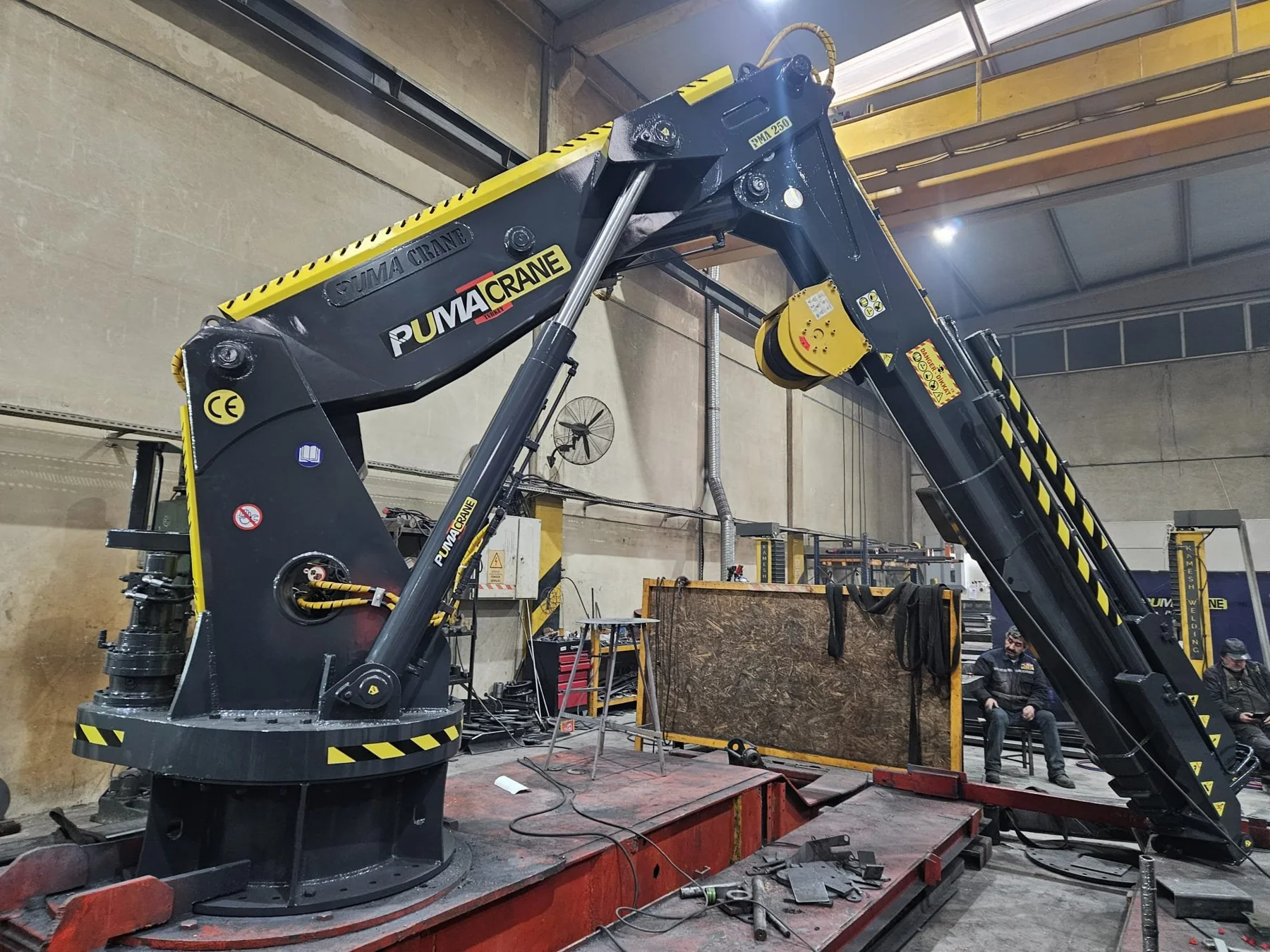Black knuckle-boom marine crane on an offshore-application vessel