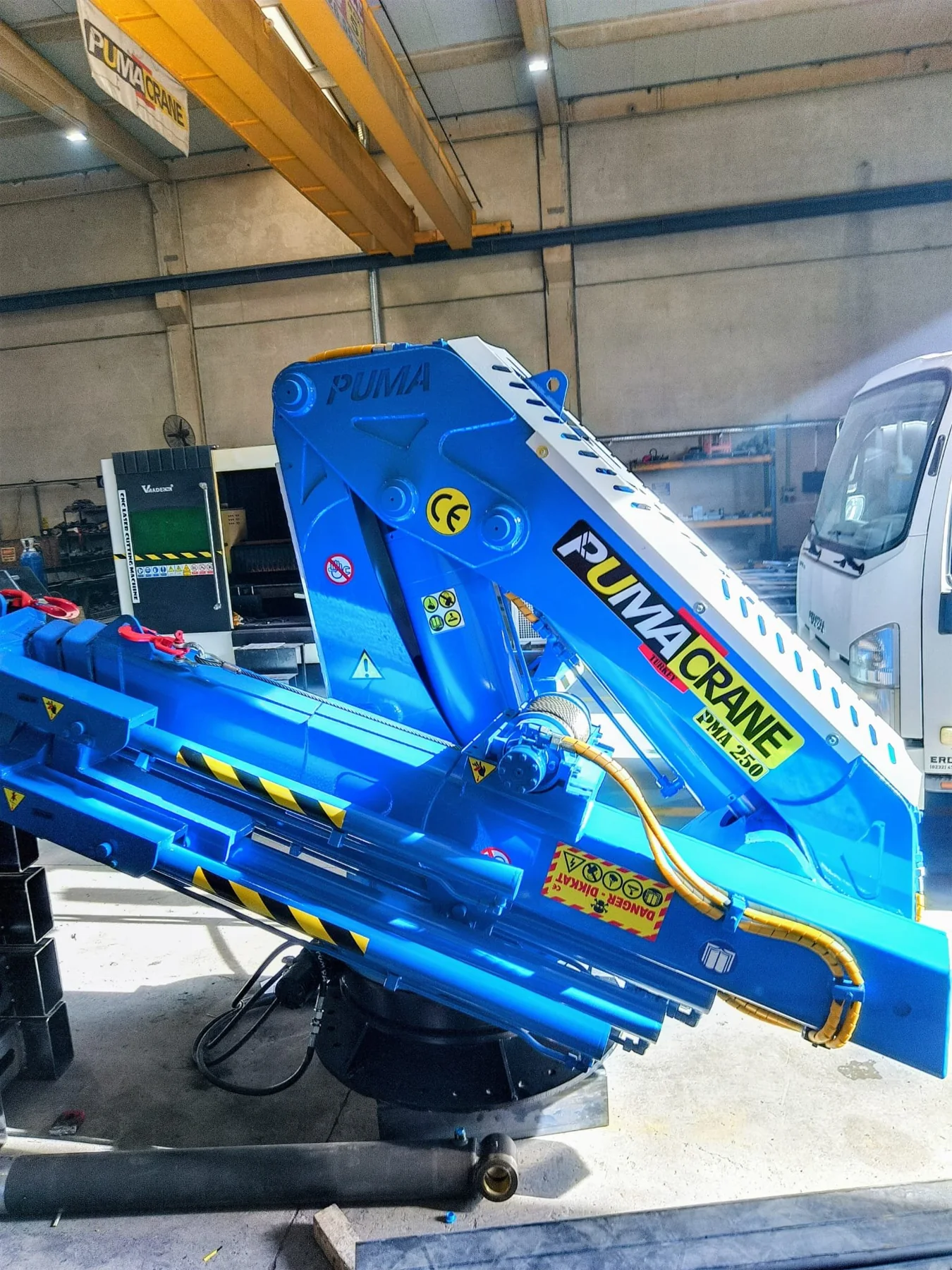 Blue folding marine crane prepared in a manufacturer workshop