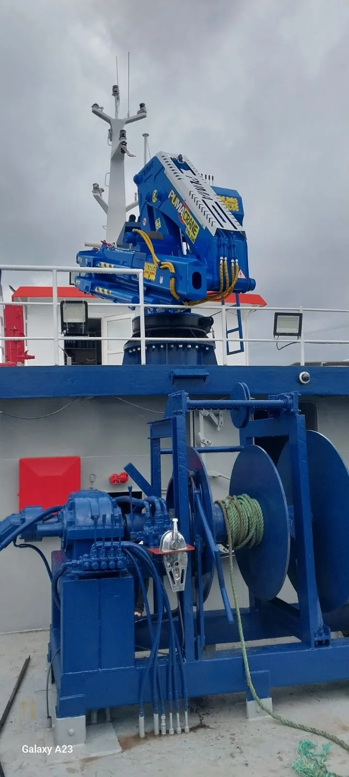 Blue marine crane with visible cable and winch arrangement