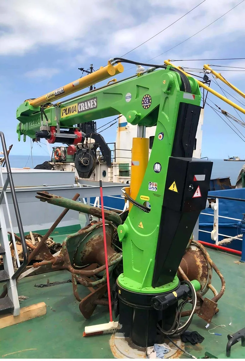 Compact green marine crane installed on a yacht or workboat