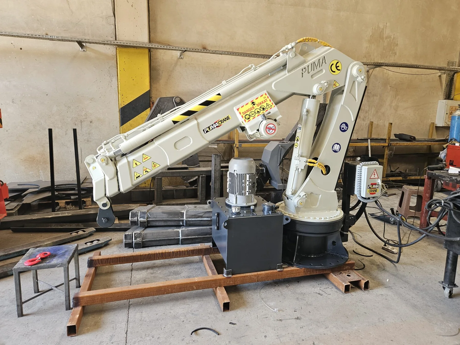 White folding marine crane prepared in a manufacturer workshop
