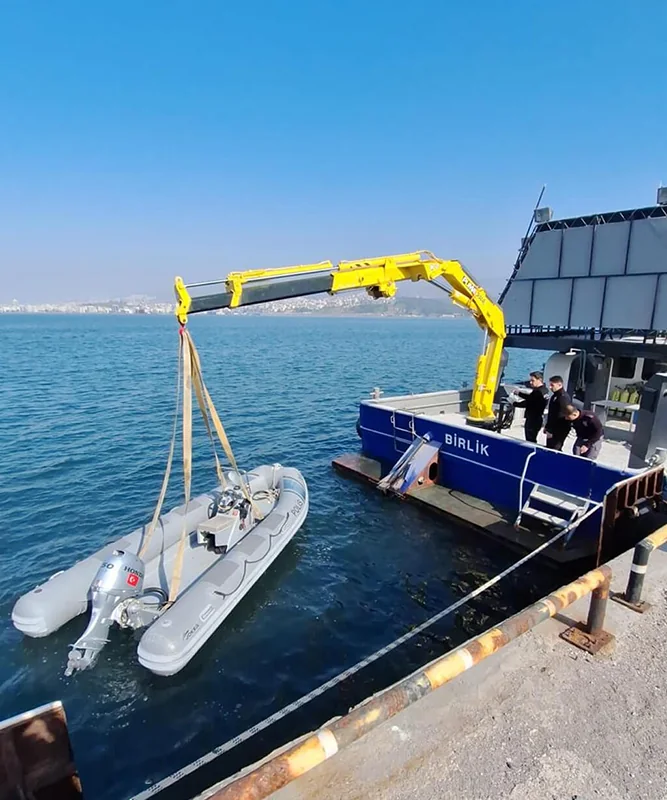 Yellow marine crane positioned for tender handling