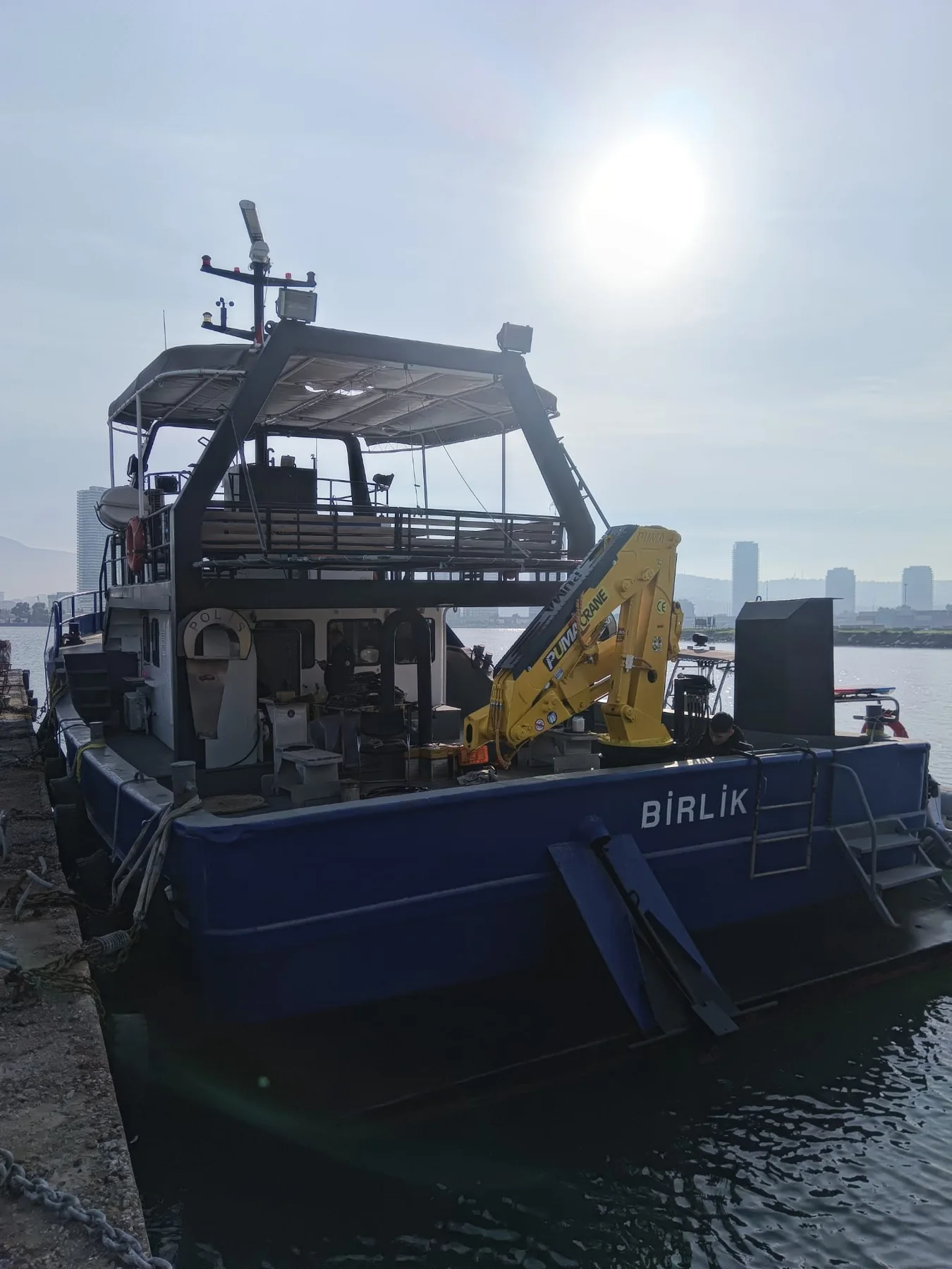 Yellow marine crane installed on a workboat deck